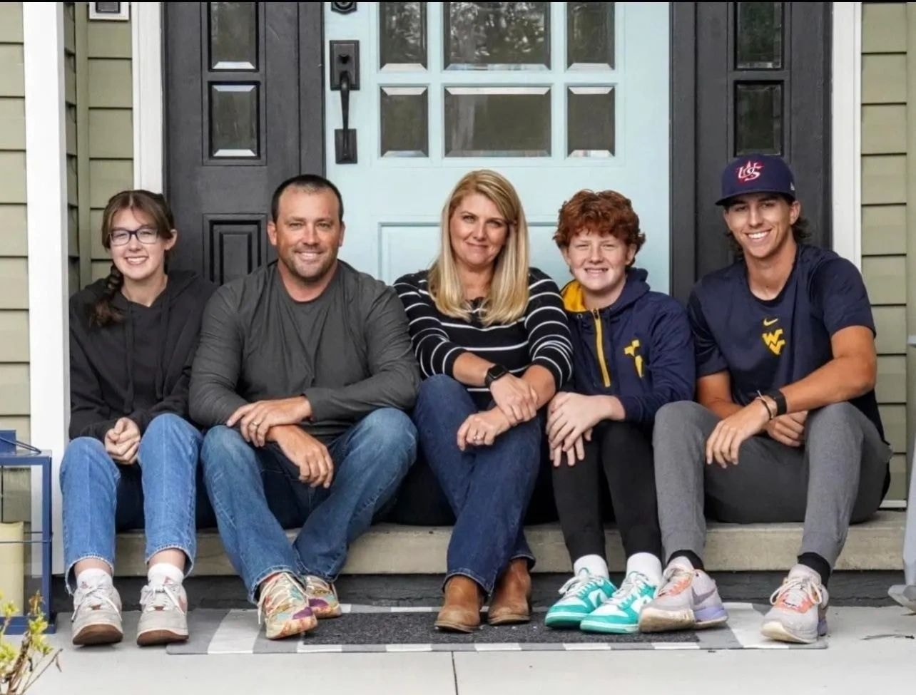 Family sitting on house steps smiling